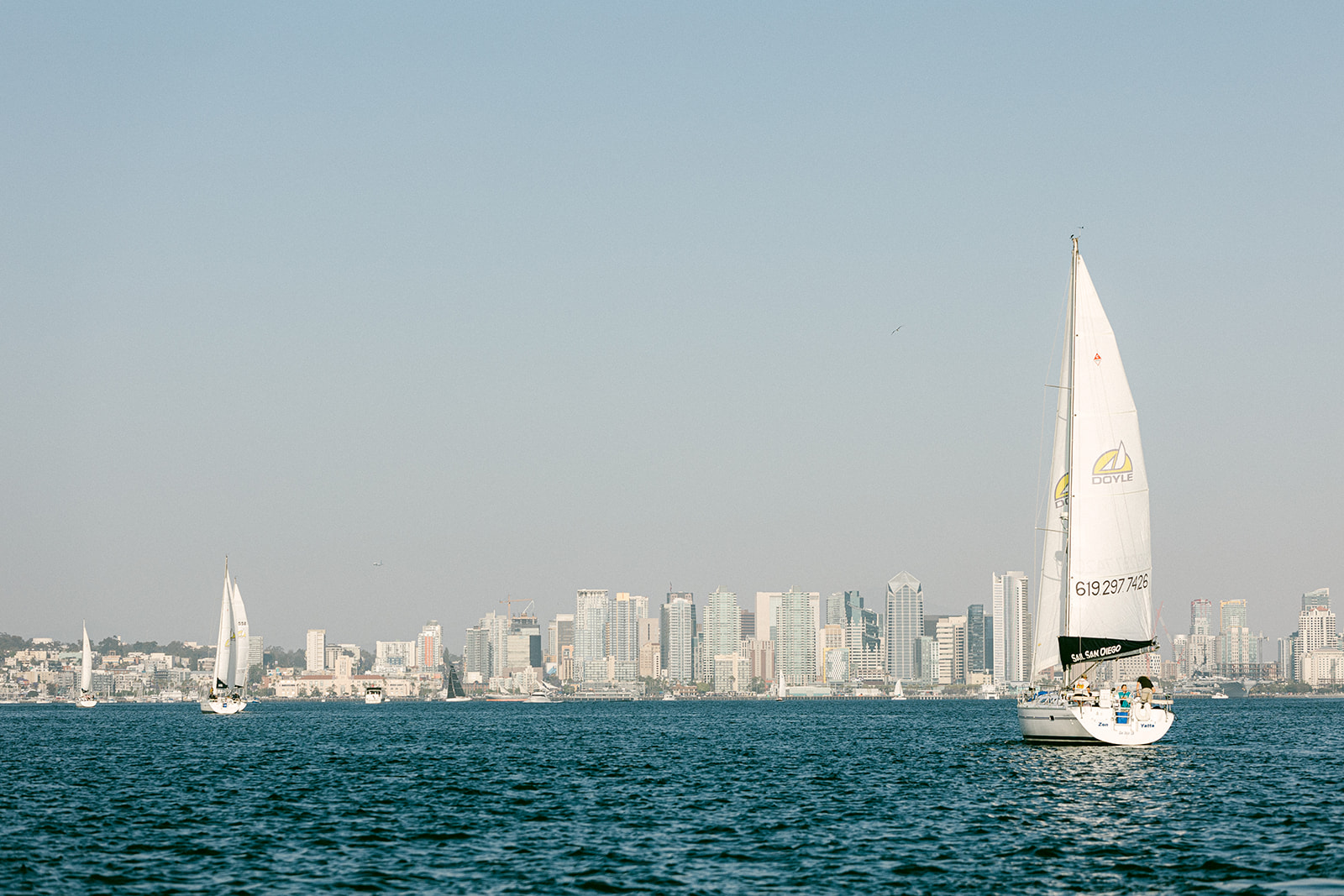 a large ship in a body of water with a city in the background