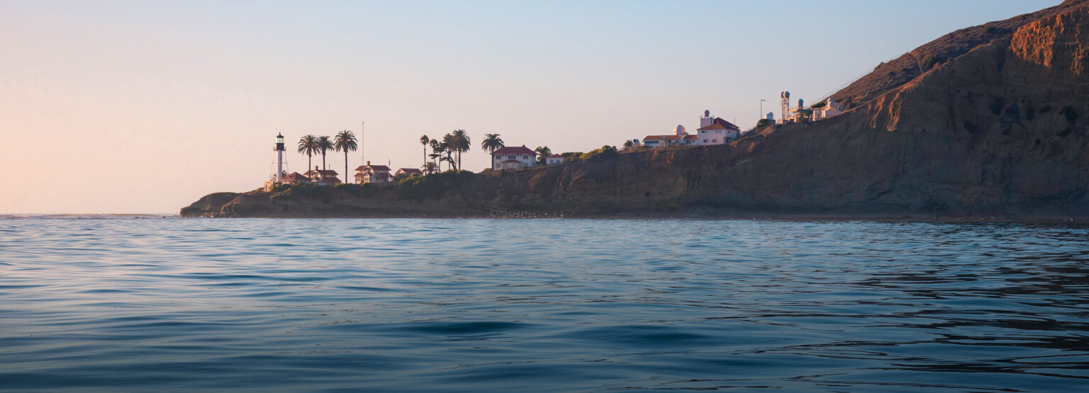 a body of water with houses on a hill